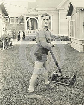 Suspicious man with a push reel lawn mower photo