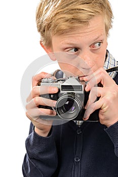 Suspicious teenage boy holding retro camera