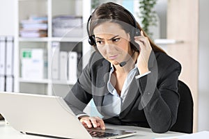 Suspicious telemarketer looking at laptop in the office