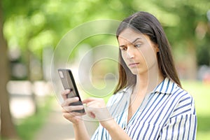 Suspicious woman checking strange news on phone