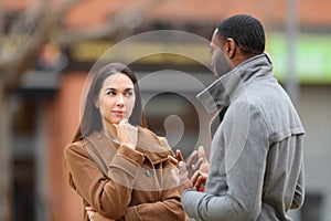 Suspicious woman listening a man talking in the street