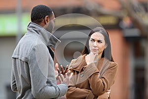 Suspicious woman listening a man talking in winter