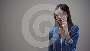 Suspicious woman looking into magnifying glass, private detective scrutinizing