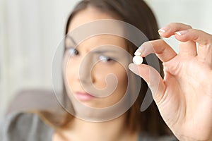 Suspicious woman looking at a pill photo