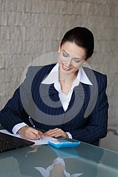 Sussessful businesswoman writing and laughing