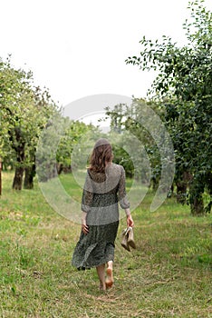Sustainability, environmental and ecology nature care concept, woman in dress walking barefoot on green grass outdoor in park,