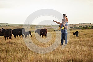 Sustainability, nature and farmer teaching daughter how to care for livestock on a cattle farm. Loving parent bonding