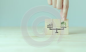 Sustainable development concept. Weight scale with green planet and money growth.