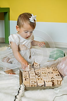 Sustainable eco-friendly safe wooden toys for baby and kids. Baby girl play with wooden blocks made with organic