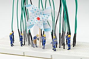Sustainable energy, alternative clean eco power concept, miniature people worker help building windmill electricity generator to