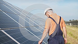 Sustainable green energy jobs, solar panel technician working with solar panels. Assistance technical worker in uniform