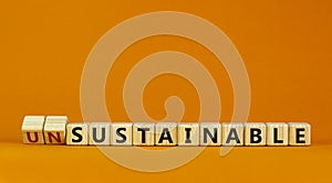 Sustainable or unsustainable symbol. Turned a cube and changed word `unsustainable` to `sustainable` on wooden cubes. Beautifu photo