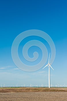 Sustainable wind energy generators against blue sky; renewable e