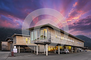 Sustainable wood office building on pillars with parking spaces underneath photo