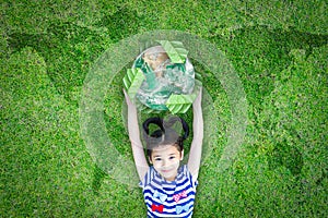 Sustainable world environment and CSR with people campaign concept with girl kid raising earth on green lawn