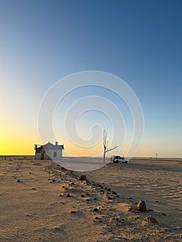 SUV 4x4 car parked near dried dead tree and Garub railroad station. Kolmanskop.