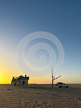 SUV 4x4 car parked near dried dead tree and Garub railroad station. Kolmanskop.