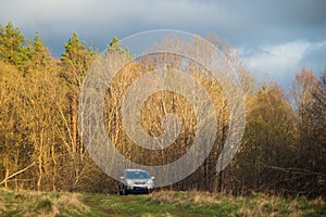 suv car in early spring forest