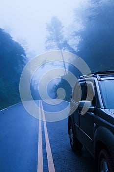 SUV car on a mountain road in the mist