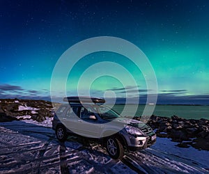 SUV car in the parking place under northen lights in Atlantic Ocean Road