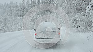 SUV goes on snow-covered road in the forest