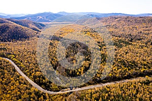 SUV near a small mountain river. Autumn forest