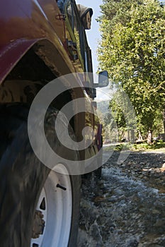 Suv offroad 4wd car rides through muddy puddle, off-road track road, with a big splash