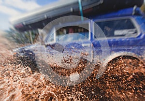 Suv offroad 4wd car rides through muddy puddle, off-road track road, with a big splash, during a jeeping competition