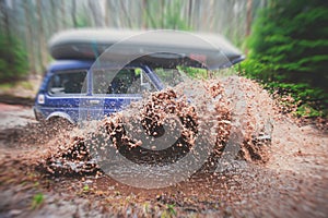 Suv offroad 4wd car rides through muddy puddle, off-road track road, with a big splash, during a jeeping competition