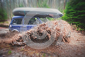 Suv offroad 4wd car rides through muddy puddle, off-road track road, with a big splash, during a jeeping competition