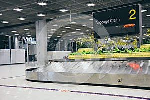 Suvarnabhumi Airport, Bangkok, Thailand - March 1, 2018 : empty metal conveyor belt with baggage claim sign in arrival hall area