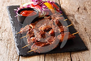 Suya kebab with ground peanuts and spices with fresh vegetable s