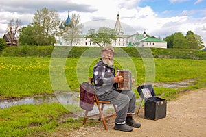 Suzdal, Russia. 28 may 2017. Street musician, old grandfather with his accordion on the background of the Kremlin of Suzdal