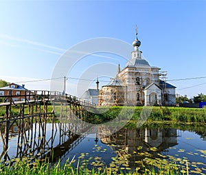 Suzdal, Russia. wooden bridge through the Kamenka River to Church of Epiphany and Nativity Cathedral of Suzdal Kremlin