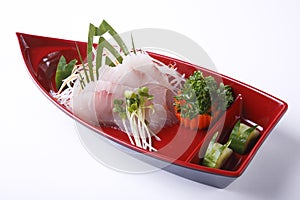 Suzuki Sashimi in red boat bowl isolated on white background photo
