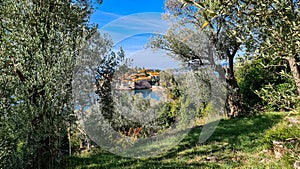 Sveti Stefan - Panoramic view framed by tree branches of idyllic island Sveti Stefan, Budva Riviera, Montenegro