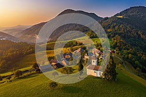 Sveti Tomaz, Slovenia - Aerial drone view of Sveti Tomaz Saint Thomas church at sunset in Skofja Loka area