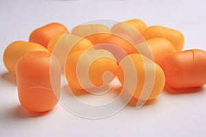 Sveti Vlas, Bulgaria - June 30, 2023: Orange plastic capsules from Kinder Surprise Eggs on white background, closeup