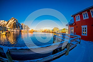 SVOLVAER, LOFOTEN ISLANDS, NORWAY - APRIL 10, 2018: Beautiful rorbu or fisherman`s houses in a port with some buildings