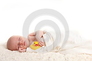 Swaddled Infant Holding a Rubber Duckie photo