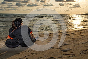 Swain sitting together on the beach and watching sunset, romance