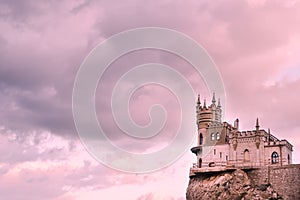 Swallow`s nest Castle on a rock in the Black sea against the background of evening clouds, in pink tinting.