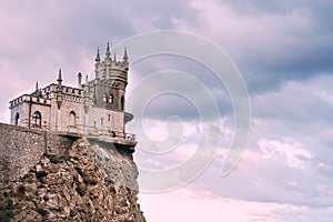 Swallow`s nest Castle on a rock in the Black sea against the background of evening clouds, in pink tinting