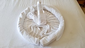 swan folded from white towels on bed in an old hotel room, top view