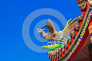 Swan statue on roof of chinese temple with blue sky