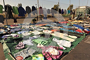 Swap meet with clothes hung on fence