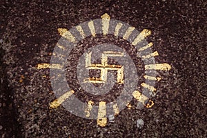 Swastika carved and drawn on a rock - an ancient solar hinduism symbol in the Indonesian culture