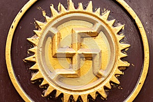 Swastika carved and drawn on a rock of temple, an ancient solar hinduism symbol in the Indian culture, India, Varanasi