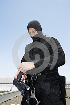 SWAT Team Officer Loading Pistol