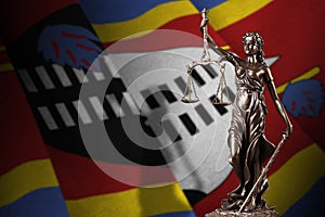 Swaziland flag with statue of lady justice and judicial scales in dark room. Concept of judgement and punishment